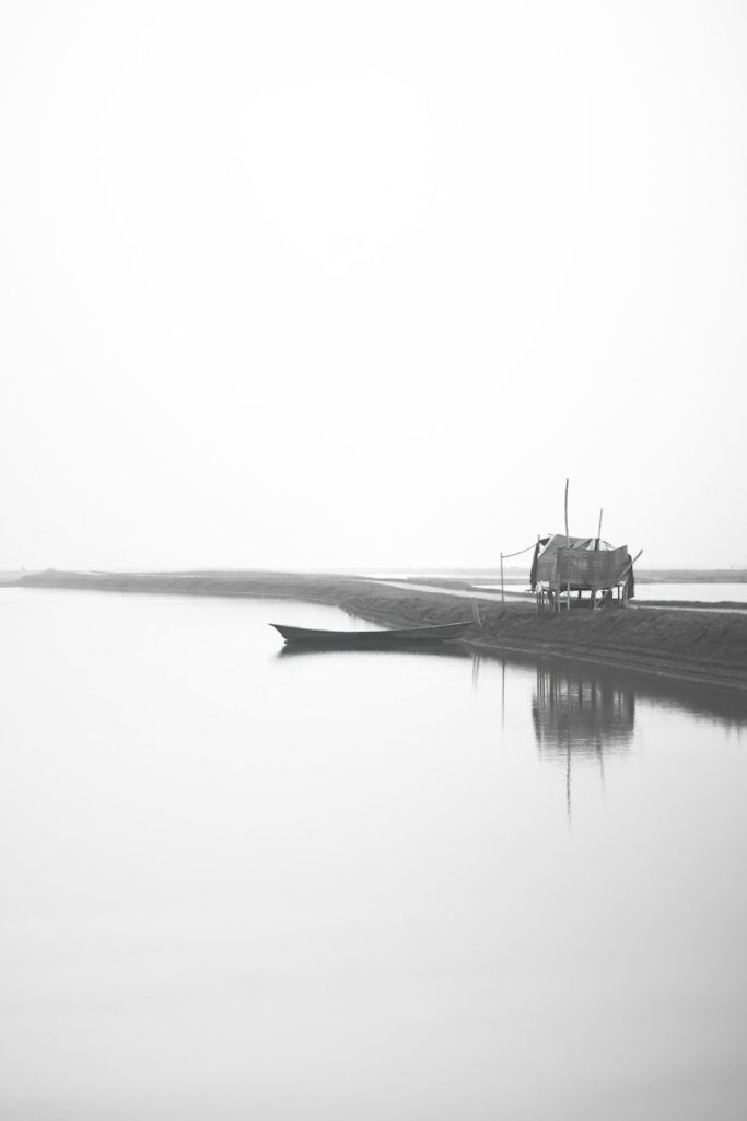 a solitary boat on calm water in black and white, symbolizing navigation through authoritarian discourse and the isolation of the people facing systemic collapse, metaphor of kairos moment