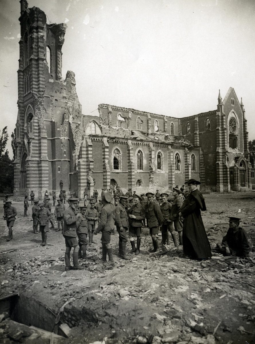 Fotografía histórica en blanco y negro de grupo de hombres frente a edificio. Representa la estructura organizativa y la base operativa del poder institucional.